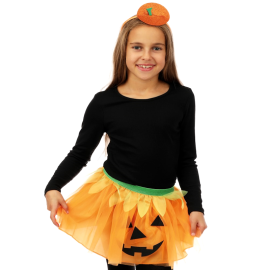Petite fille joyeuse habillée en costume de citrouille avec serre-tête et tutu pour Halloween.